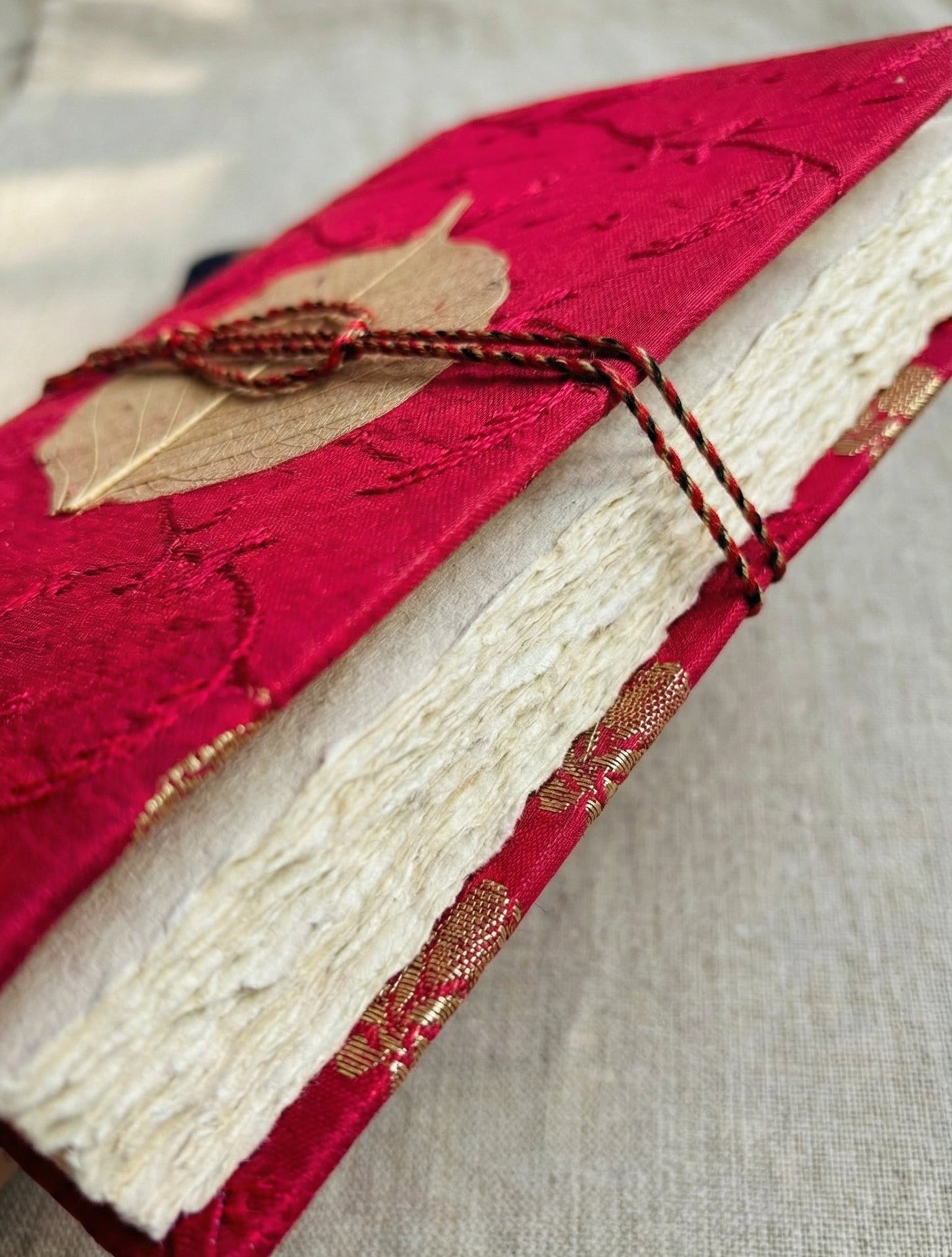 Close-up of a red fabric cover with a textured surface on a neutral background