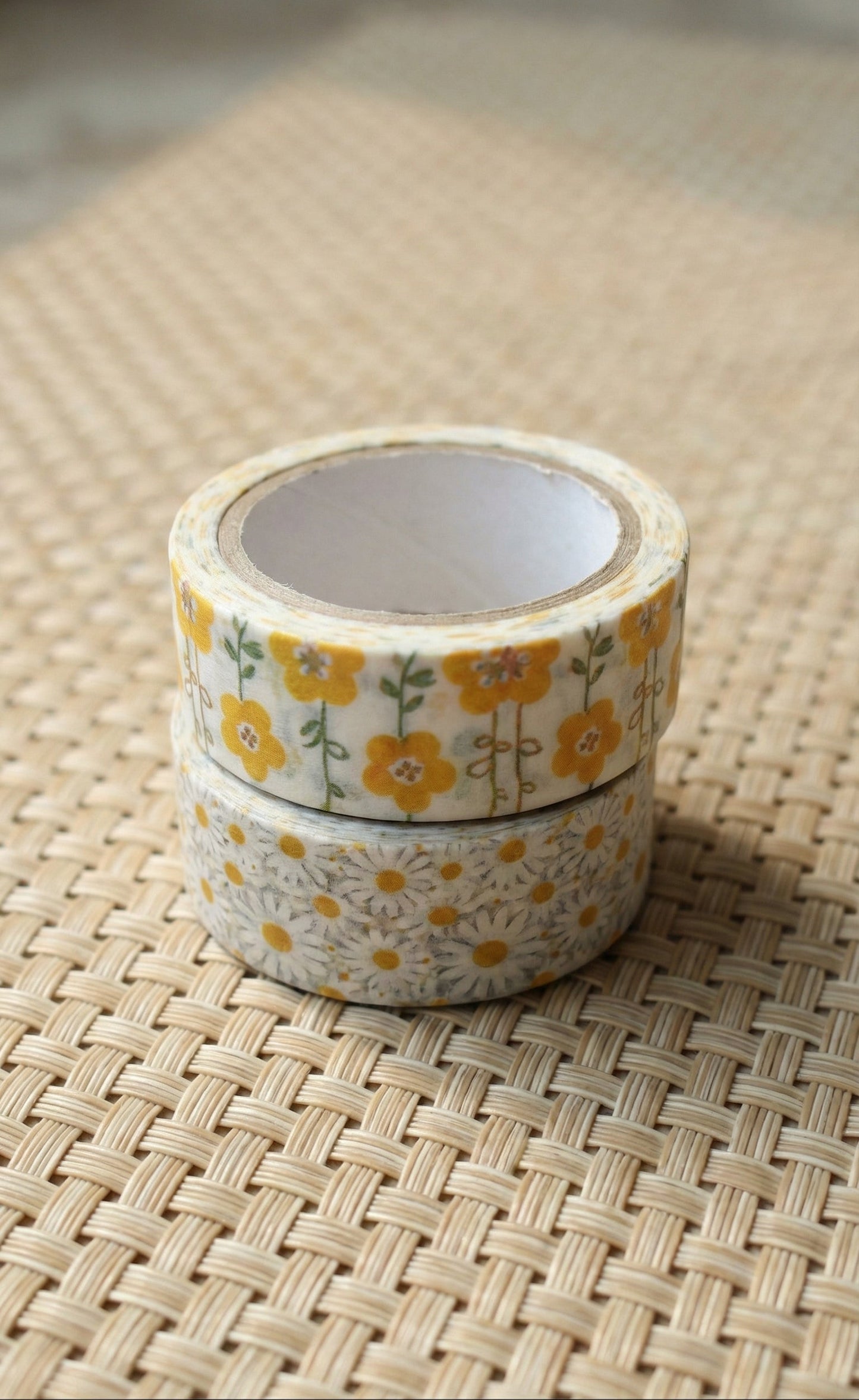 Two rolls of floral-patterned tape on a woven surface